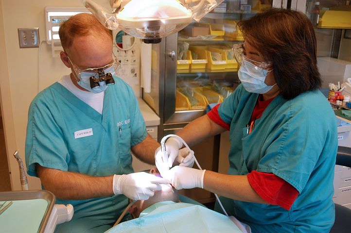 two dentists checking a patient's mouth